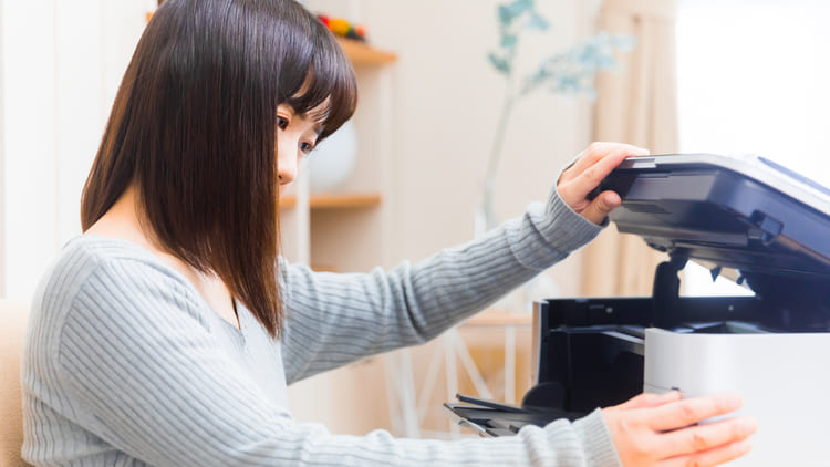 プリンターを開ける女性